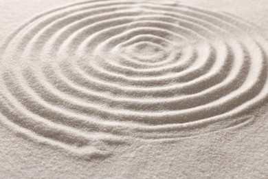 Photo of Pattern drawn on white sand, closeup. Zen garden