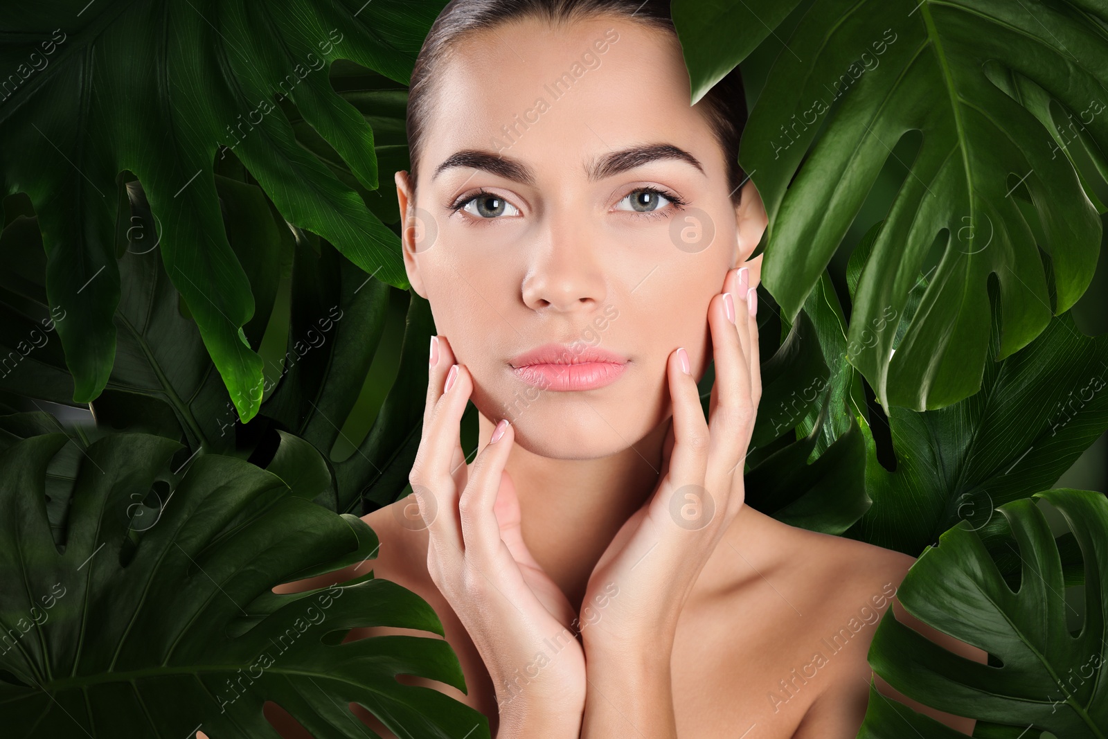 Image of Beautiful young woman surrounded by green leaves feeling harmony while enjoying nature