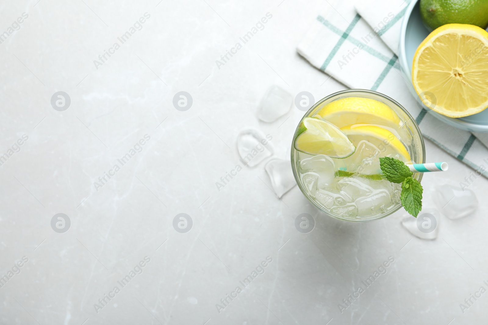 Photo of Flat lay composition of delicious lemonade with soda water and mint on light grey table, space for text. Fresh summer cocktail