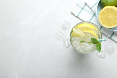 Photo of Flat lay composition of delicious lemonade with soda water and mint on light grey table, space for text. Fresh summer cocktail