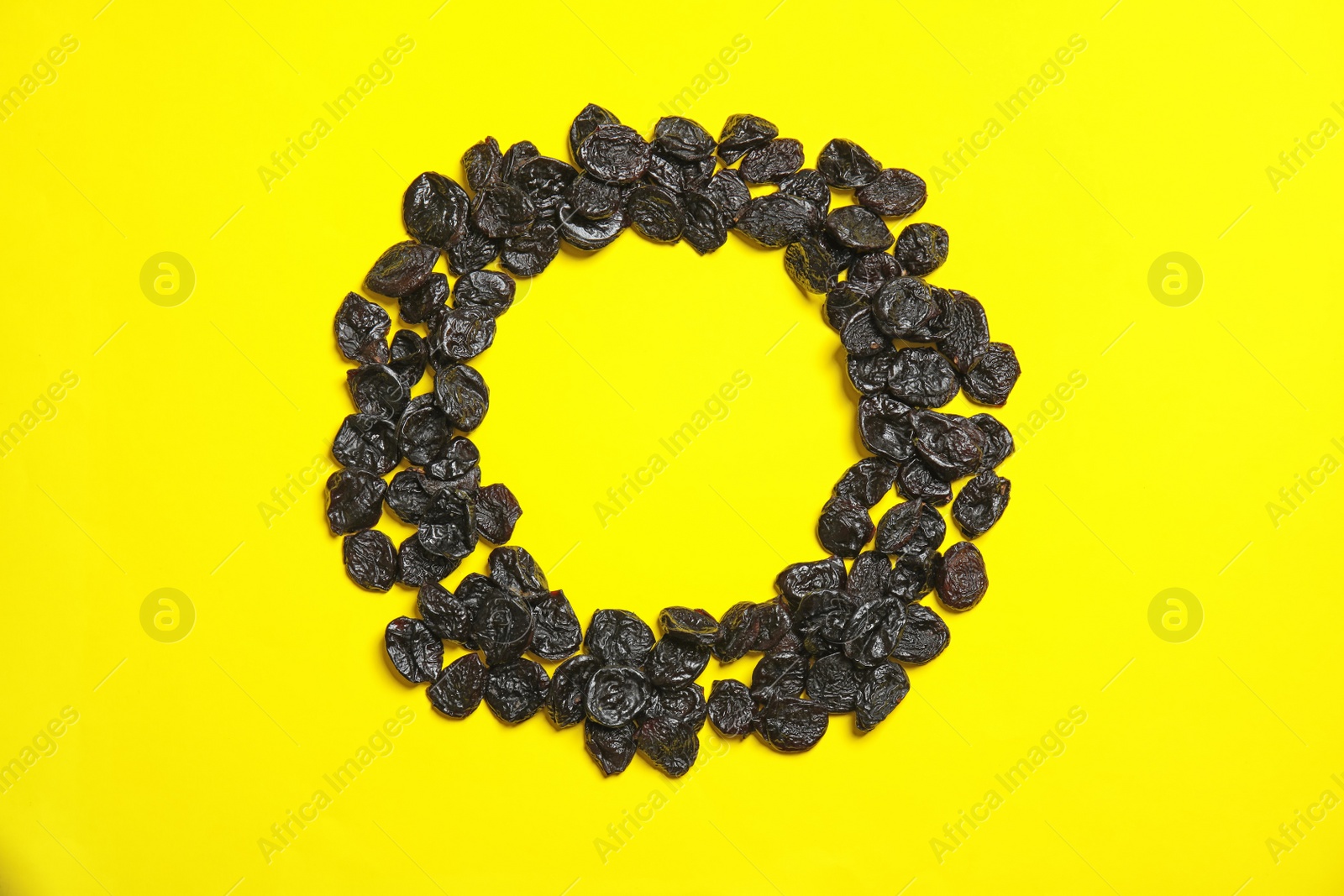 Photo of Frame made of tasty prunes on color background, top view with space for text. Dried fruit as healthy snack