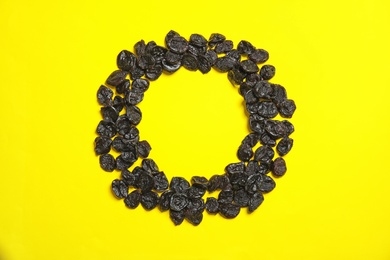 Frame made of tasty prunes on color background, top view with space for text. Dried fruit as healthy snack