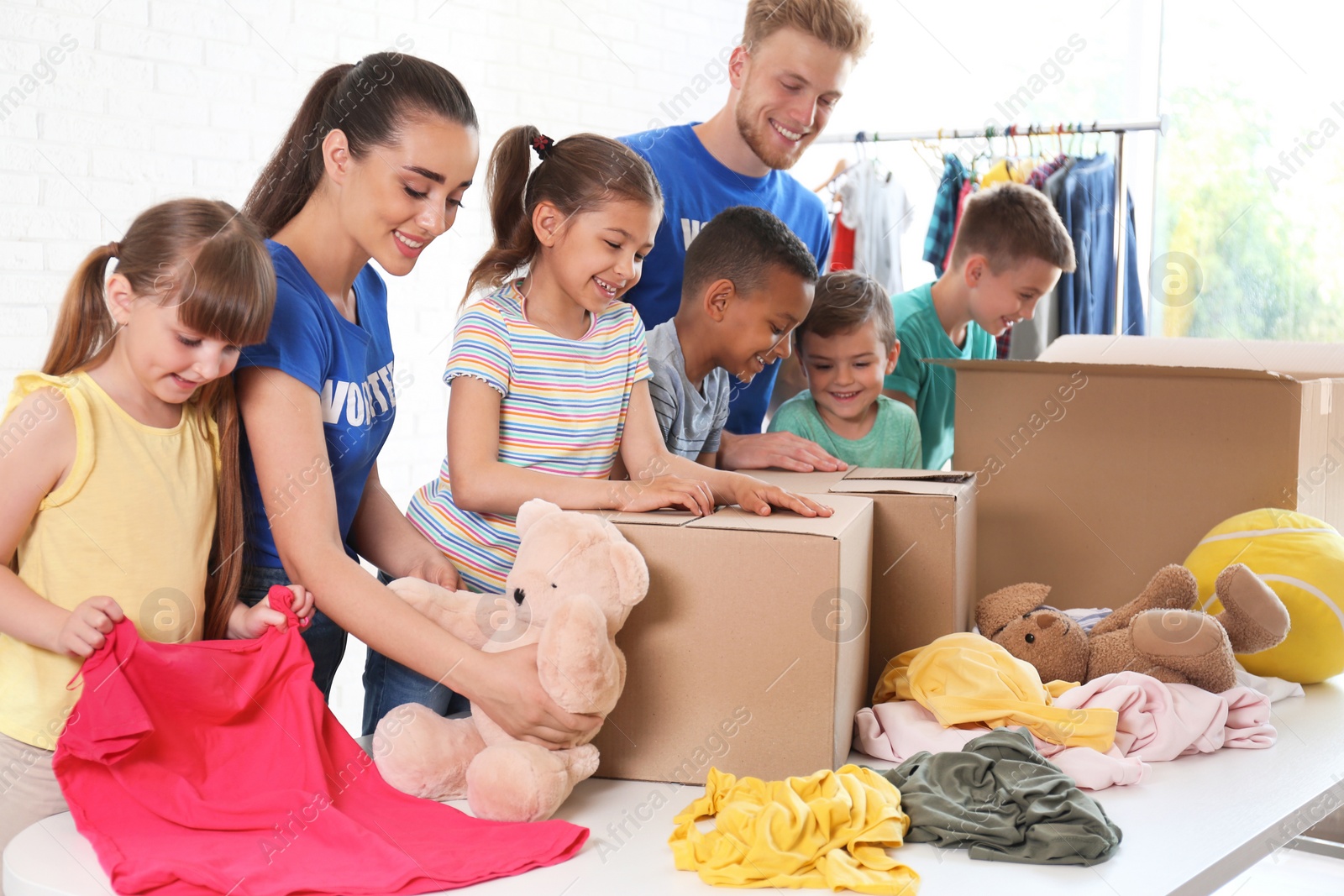 Photo of Volunteers with children sorting donation goods indoors
