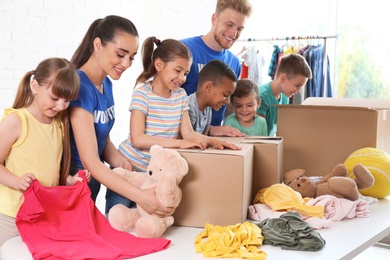 Photo of Volunteers with children sorting donation goods indoors