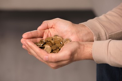 Photo of Closeup view of man holding coins indoors