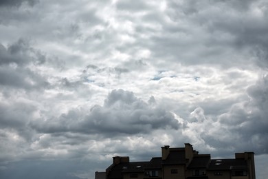 Photo of View of buildings under sky with heavy rainy clouds
