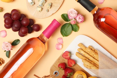 Flat lay composition with bottles of delicious rose wine on beige background