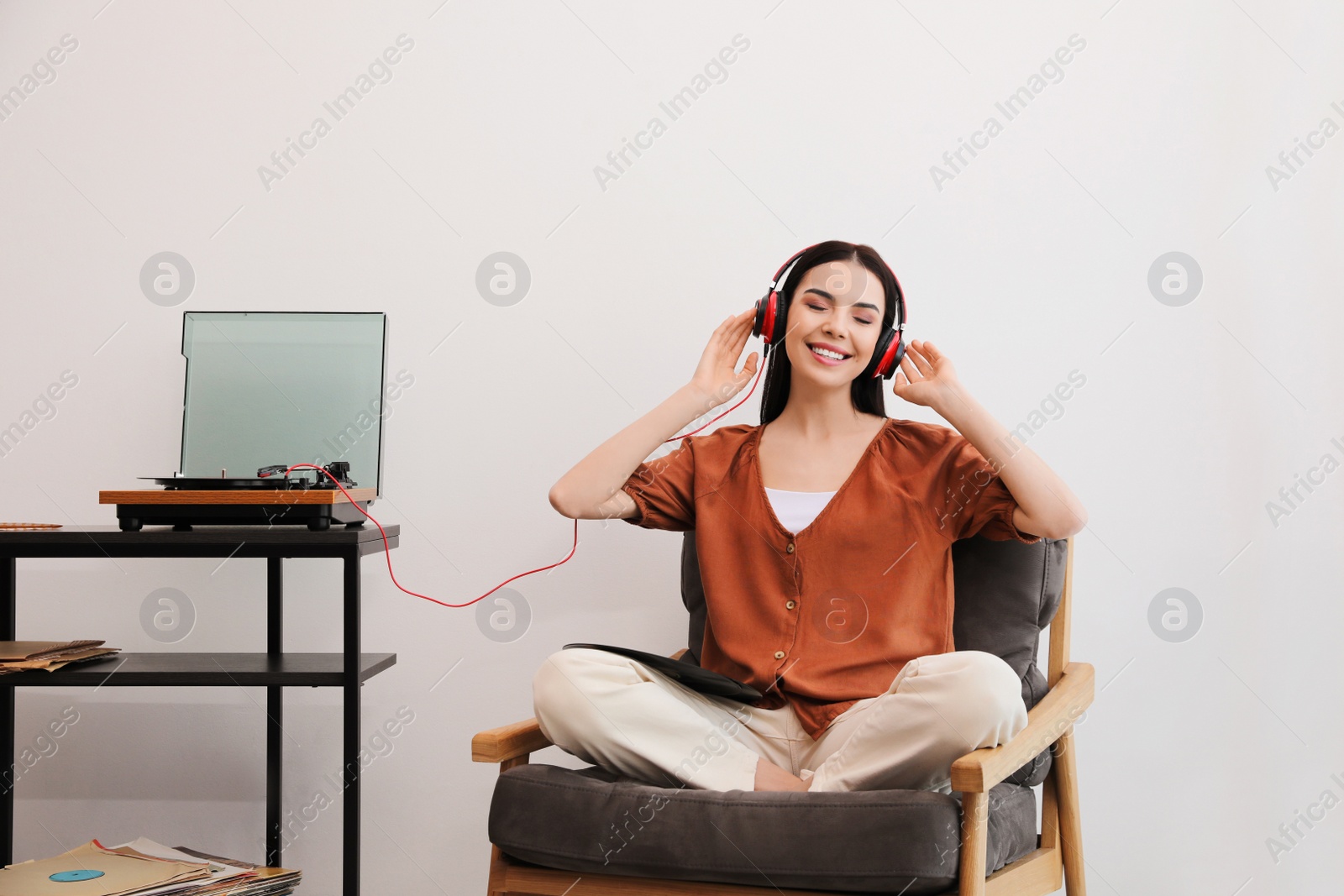 Photo of Woman listening to music with turntable at home