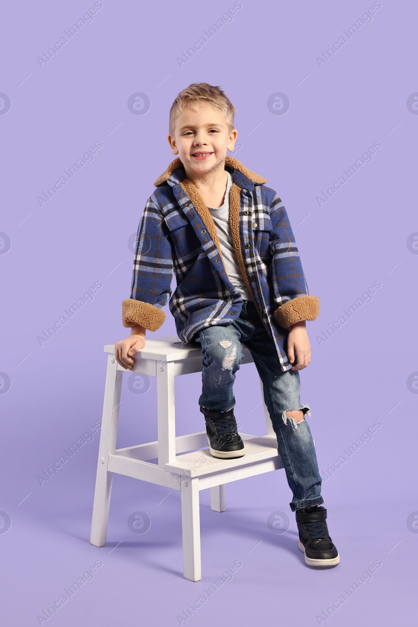 Photo of Fashion concept. Stylish boy posing on violet background