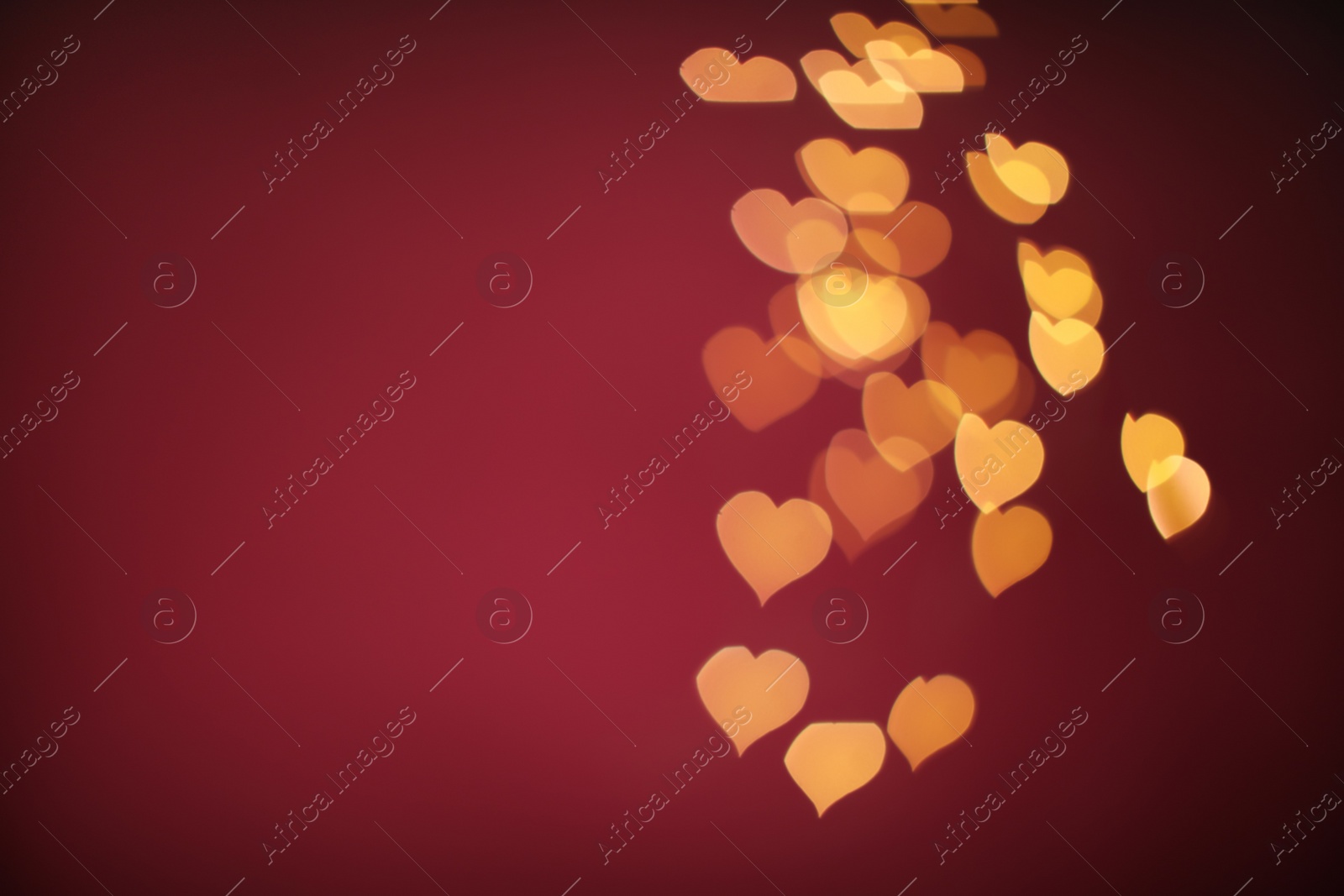 Photo of Blurred view of beautiful lights on burgundy background, space for text. Bokeh effect