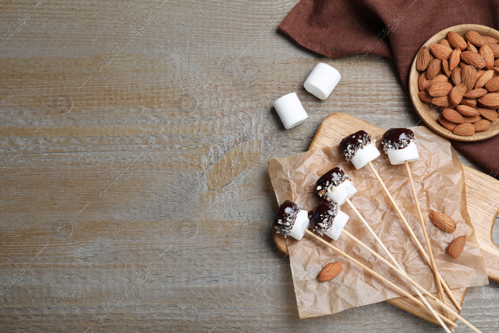 Photo of Delicious marshmallows covered with chocolate on wooden table, flat lay. Space for text