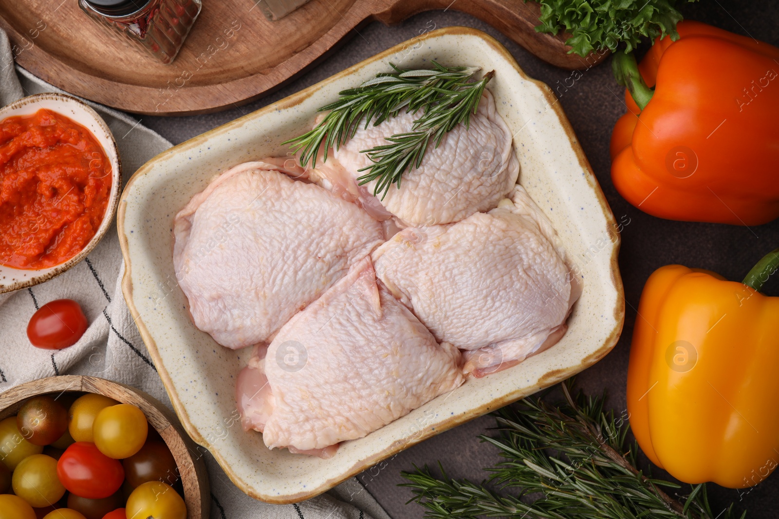 Photo of Flat lay composition with marinade, raw chicken, rosemary and other products on table