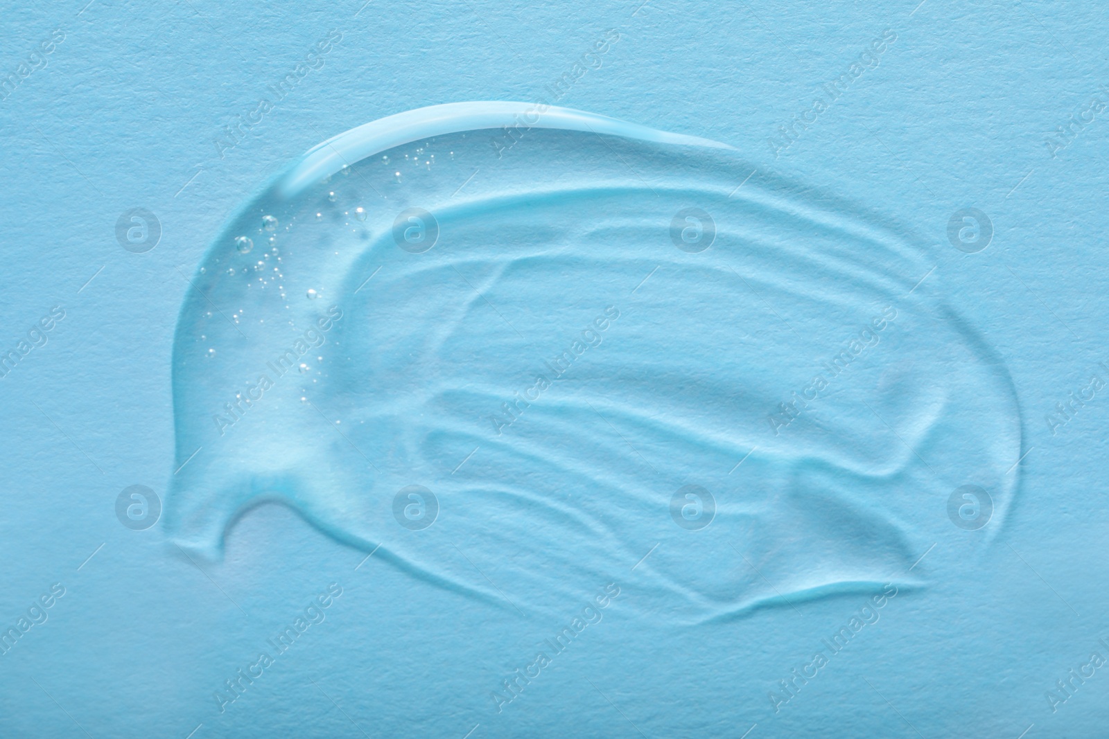 Photo of Smear of ointment on light blue background, top view