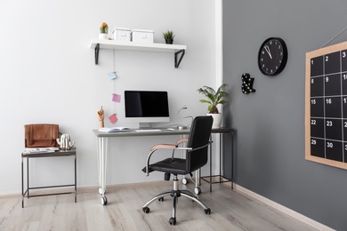 Photo of Comfortable workplace with computer on desk in home office