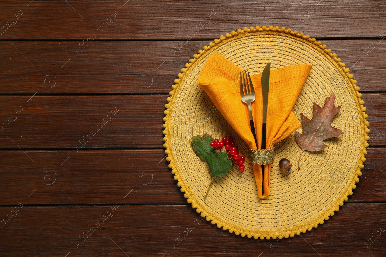 Photo of Autumn table setting. Cutlery, napkin, viburnum berries and leaf on wooden background, top view with space for text