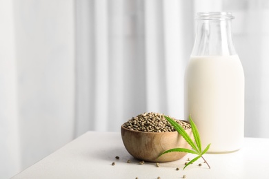 Composition with bottle of hemp milk on white table indoors. Space for text