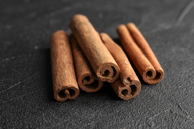 Photo of Aromatic cinnamon sticks on dark grey background