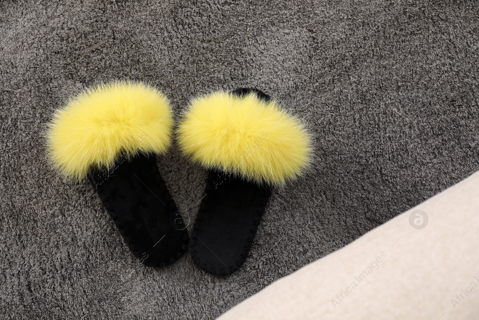 Photo of Yellow warm slippers on floor in room, flat lay