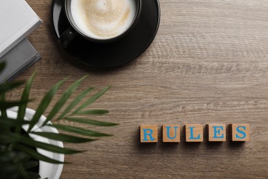 Photo of Word Rules made of cubes with letters on wooden table, flat lay