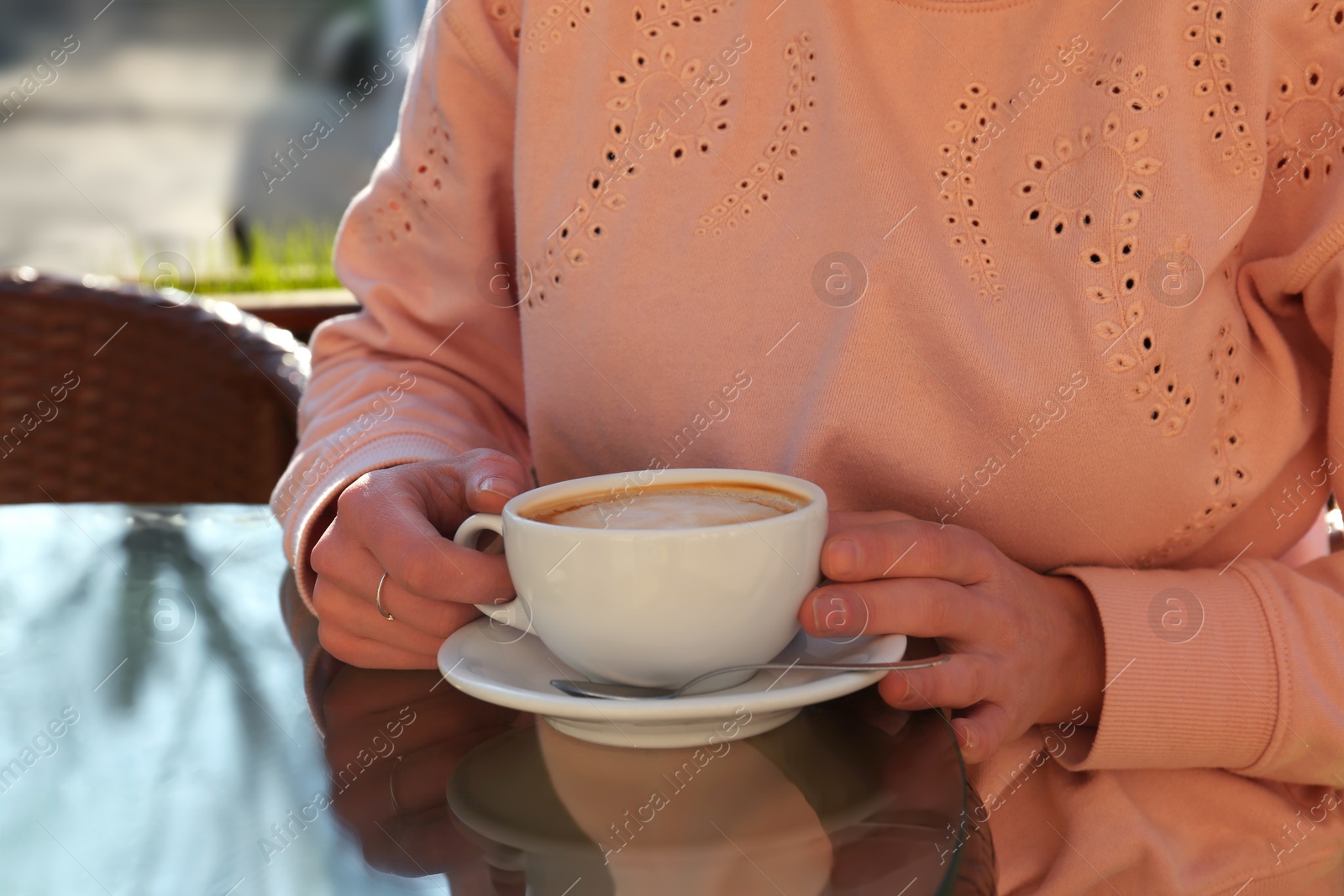 Photo of Woman with cup of fresh aromatic coffee at table in cafe