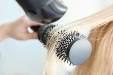 Photo of Professional hairdresser working with client in salon