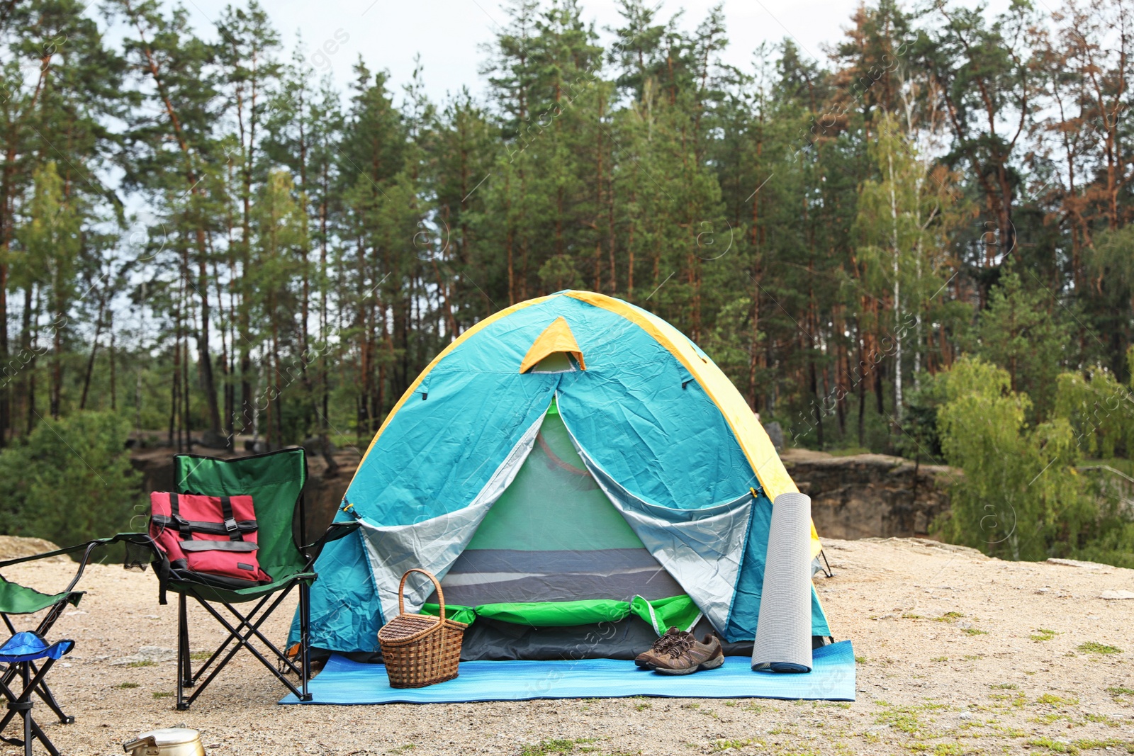 Photo of Camping tent and accessories in wilderness on summer day