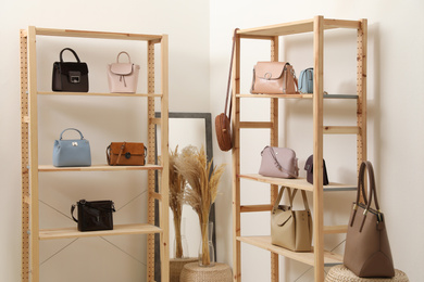 Photo of Stylish woman's bags on shelves in boutique