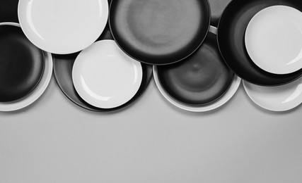 Photo of Different plates on light grey background, flat lay. Space for text