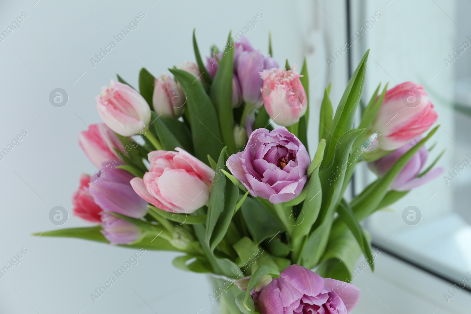 Photo of Beautiful bouquet of colorful tulip flowers indoors, closeup