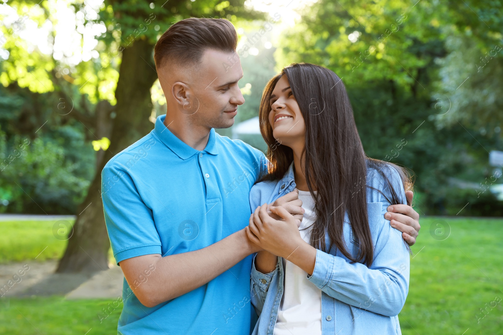 Photo of Happy young couple having good time together in park