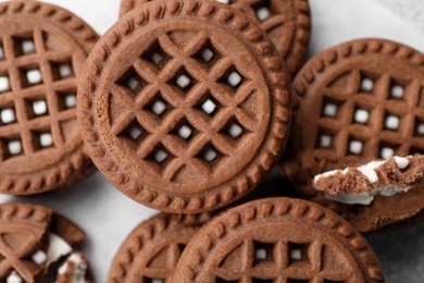 Tasty chocolate sandwich cookies with cream on table, flat lay