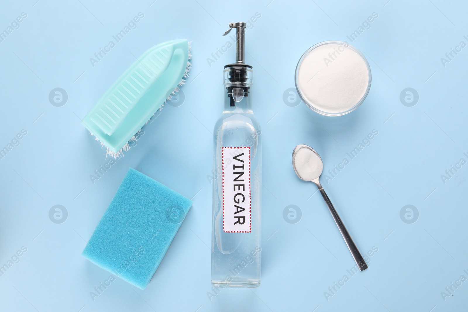 Photo of Eco friendly natural cleaners. Flat lay composition with bottle of vinegar on light blue background