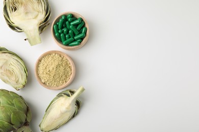 Photo of Bowls with pills, powder and fresh artichokes on white background, flat lay. Space for text