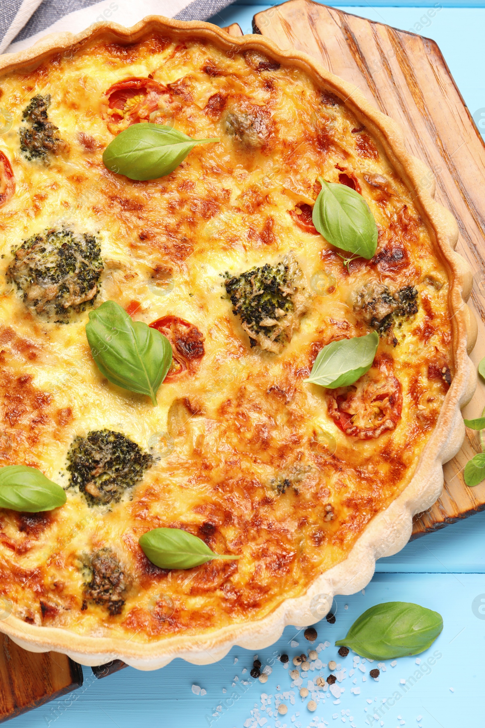 Photo of Delicious homemade vegetable quiche on light blue table, top view