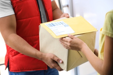 Photo of Woman receiving parcels from courier on doorstep, closeup