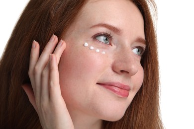 Photo of Beautiful woman with freckles and cream on her face against white background, closeup