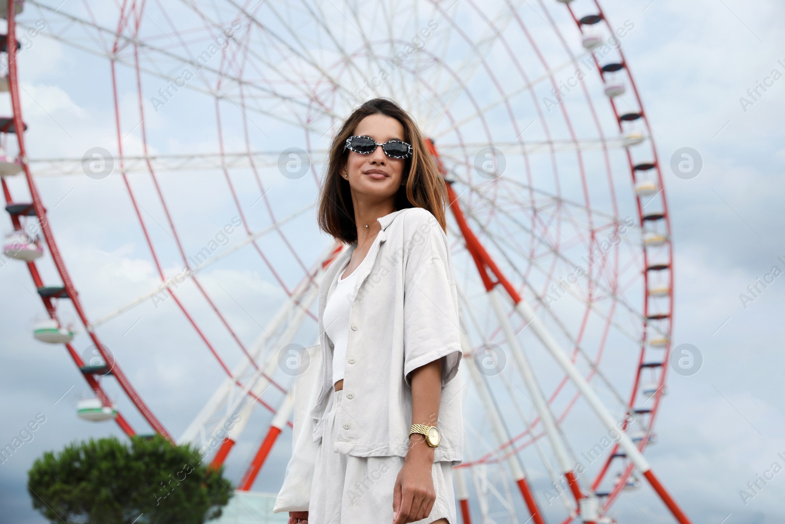 Photo of Beautiful young woman near Ferris wheel outdoors