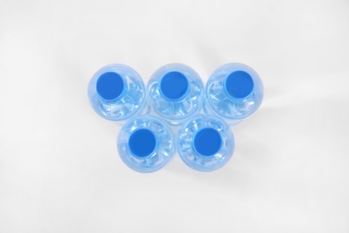 Photo of Plastic bottles with pure water on white background, top view