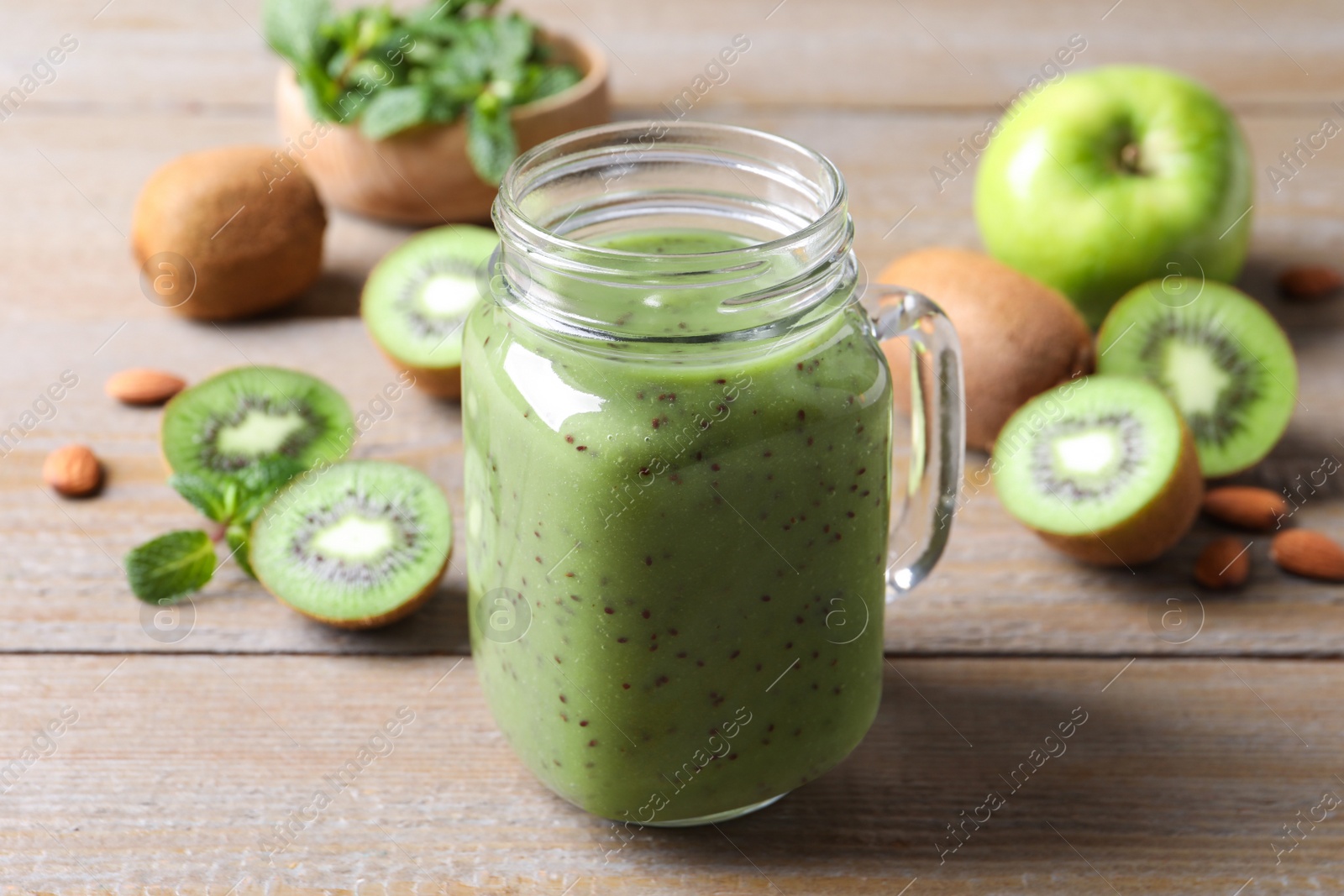 Photo of Delicious kiwi smoothie and fresh fruits on wooden table