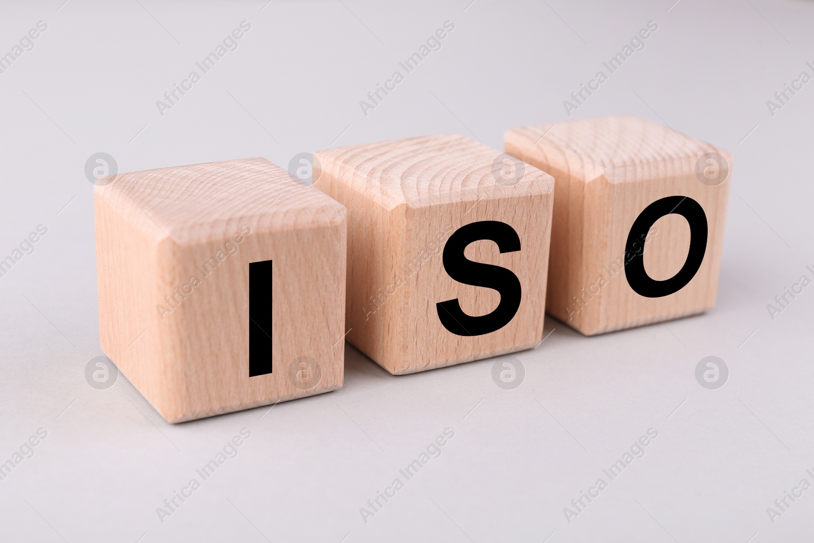Photo of International Organization for Standardization. Cubes with abbreviation ISO on light grey background, closeup