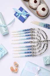 Flat lay composition with Hanukkah menorah and gift boxes on light background