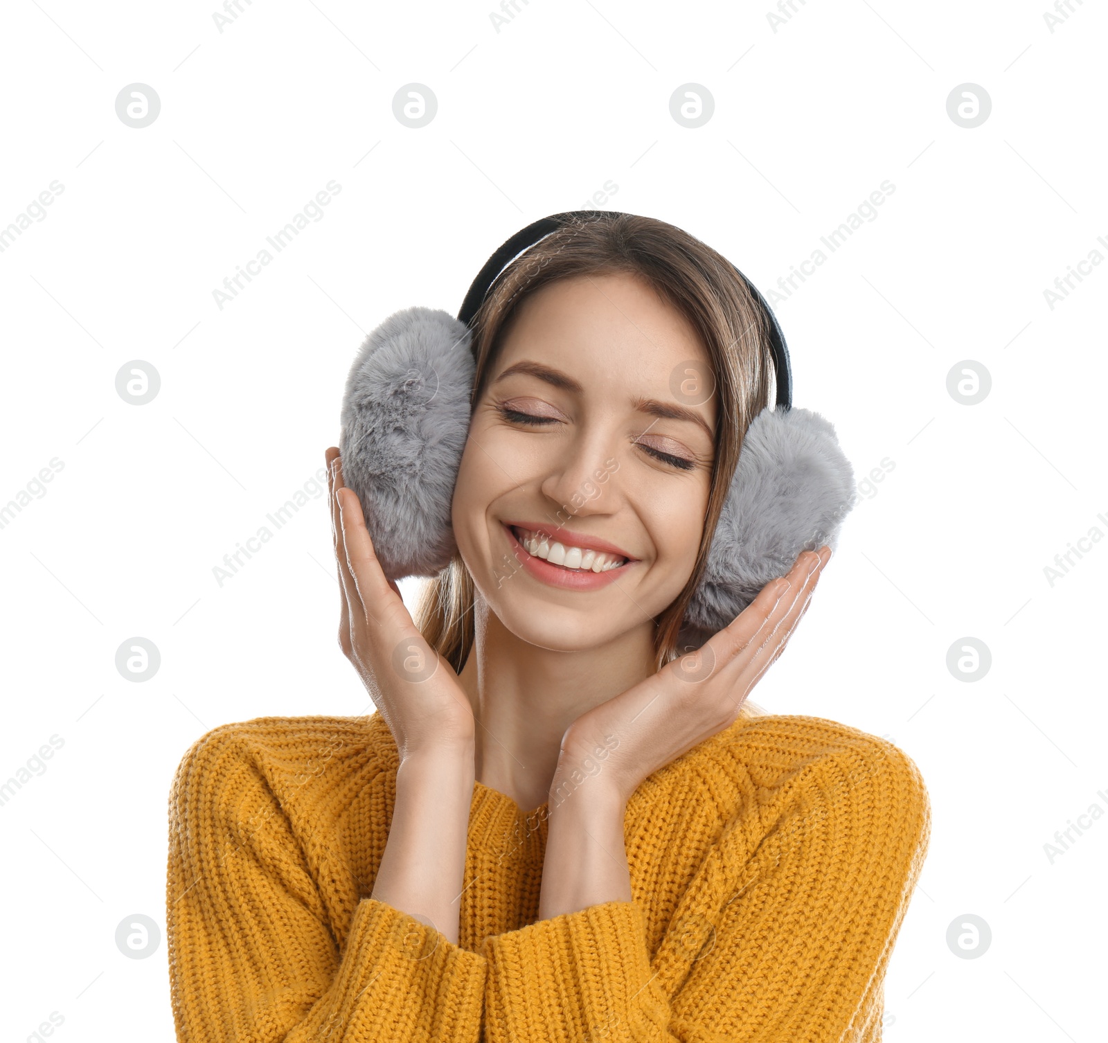 Photo of Happy woman wearing warm earmuffs on white background