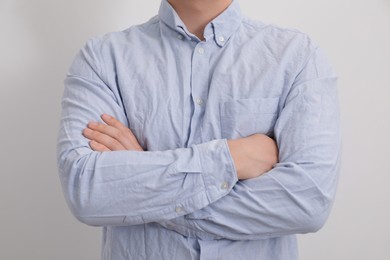 Man wearing rumpled shirt on white background, closeup