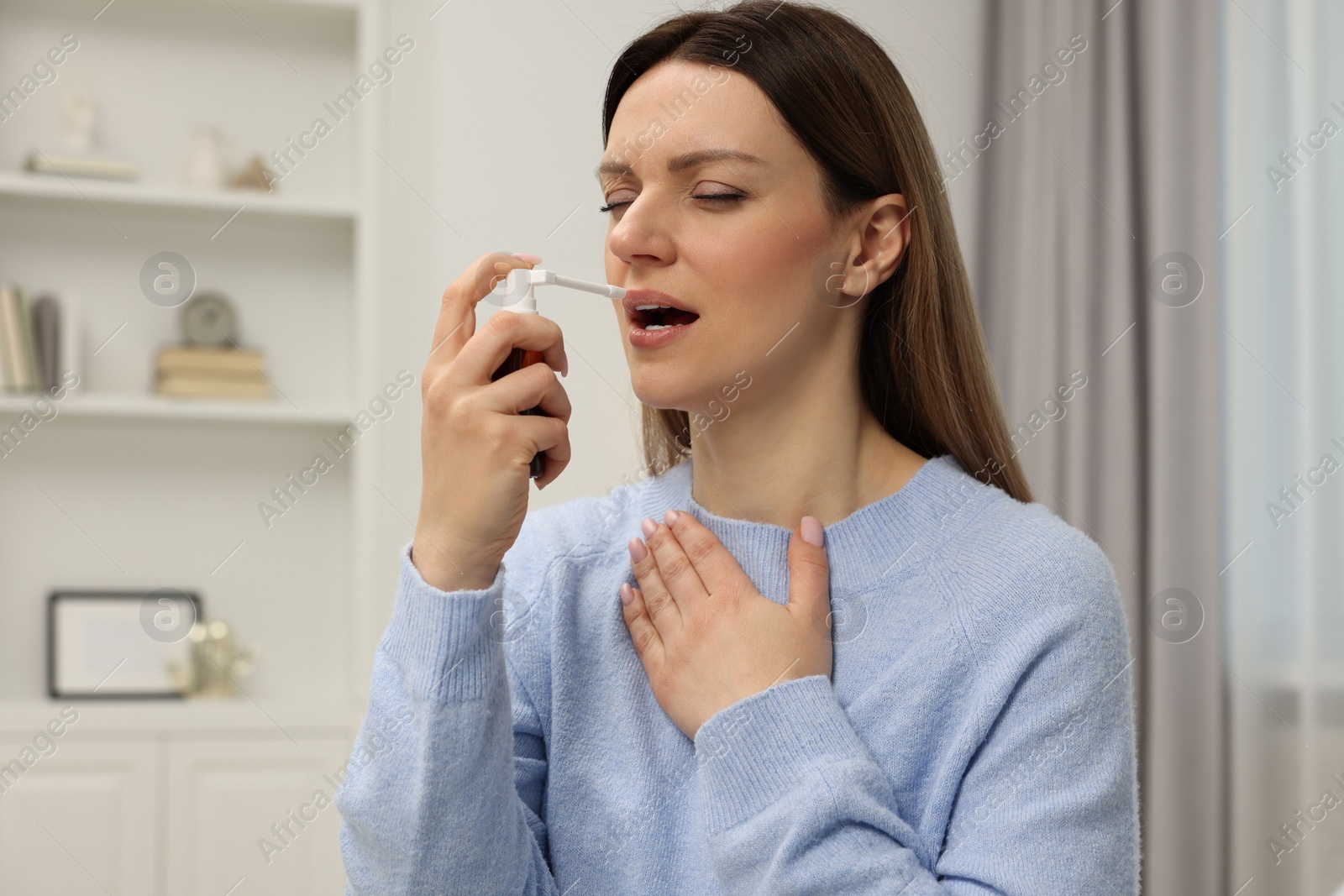 Photo of Adult woman using throat spray at home