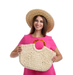 Beautiful young woman with stylish straw bag on white background