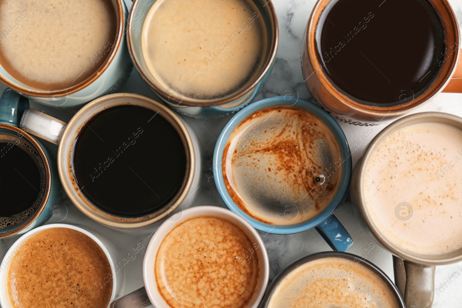 Photo of Many cups of different aromatic hot coffee on table, top view