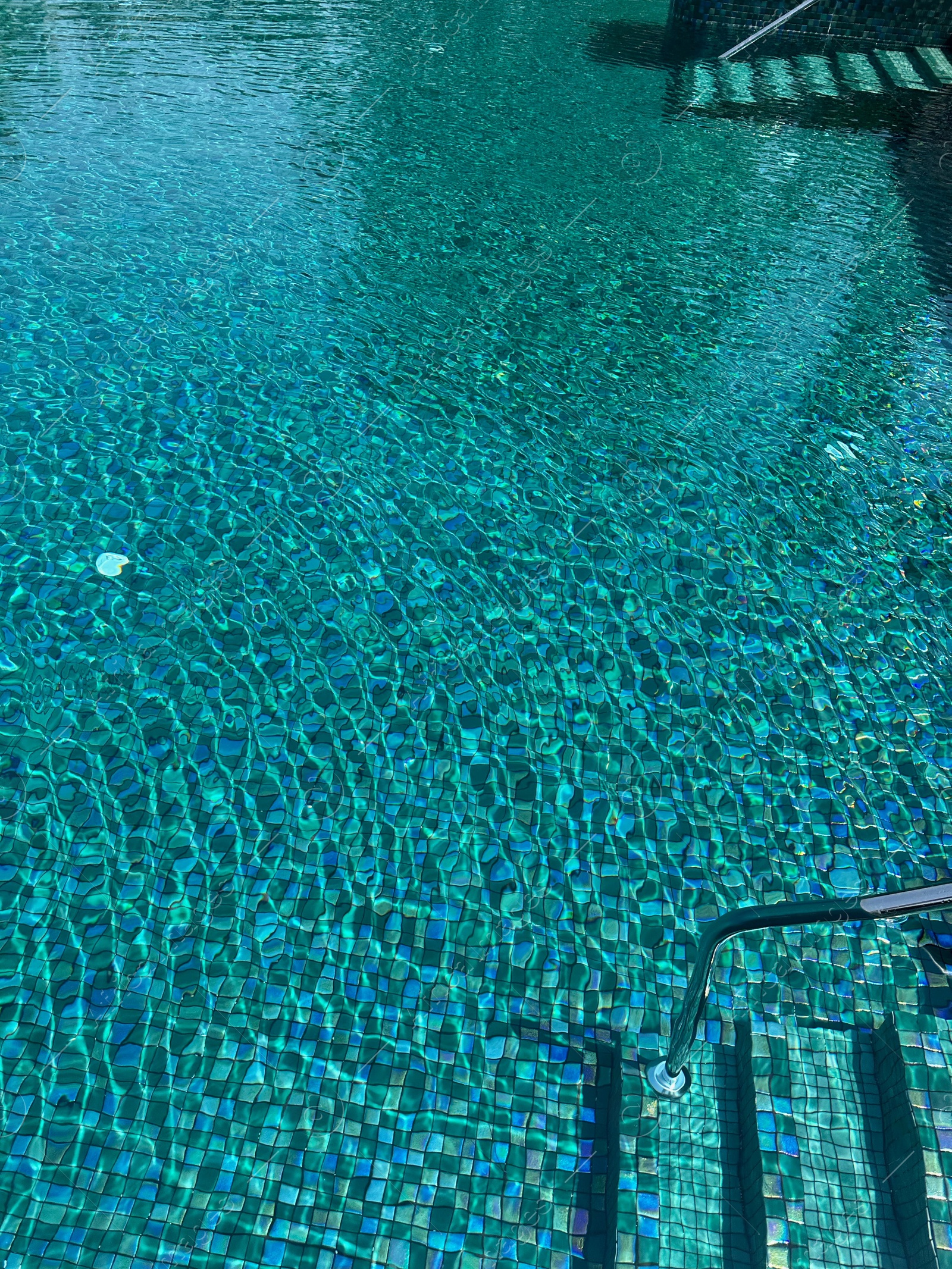 Photo of Metal rail and steps in outdoor swimming pool