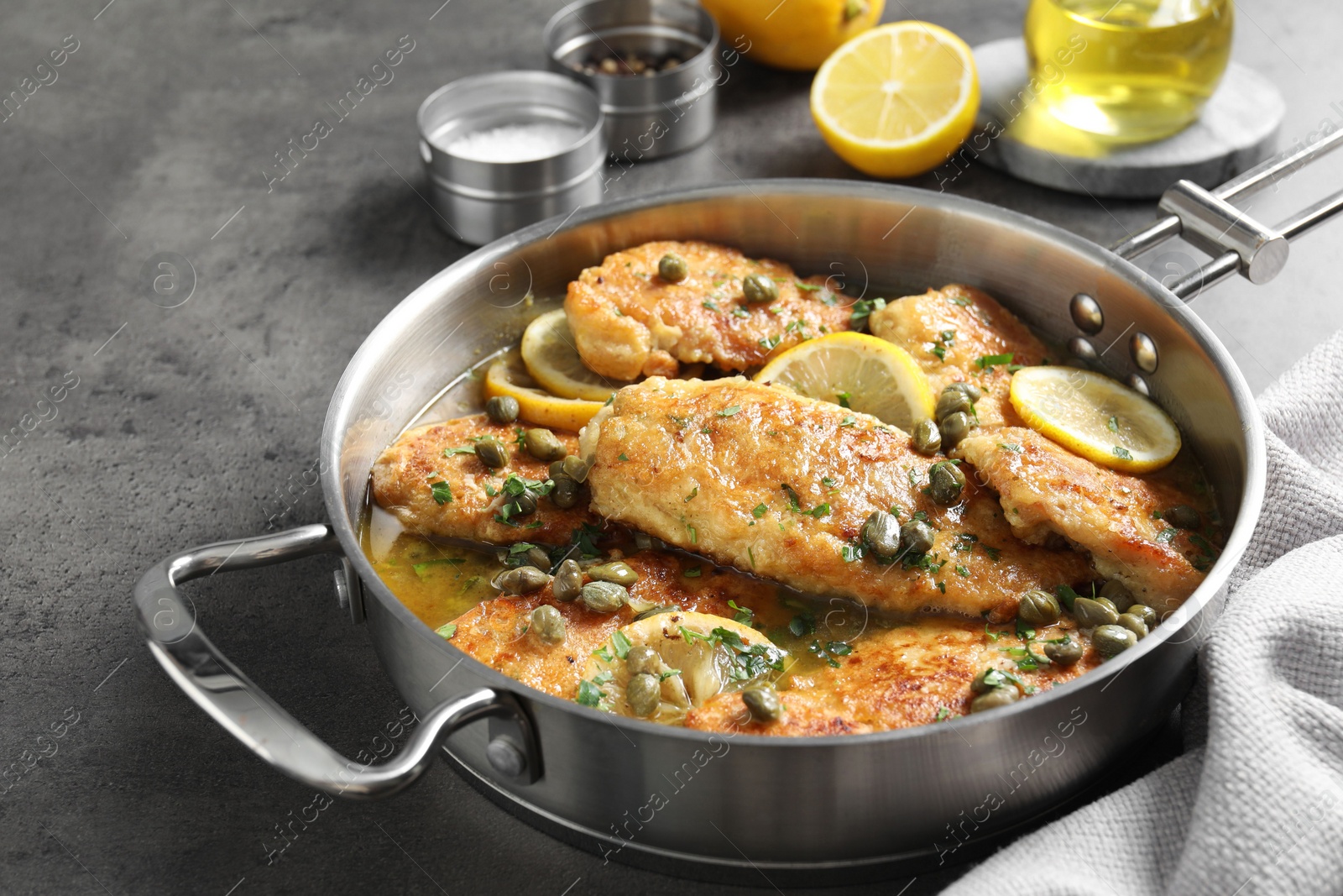 Photo of Delicious chicken piccata on grey table, closeup