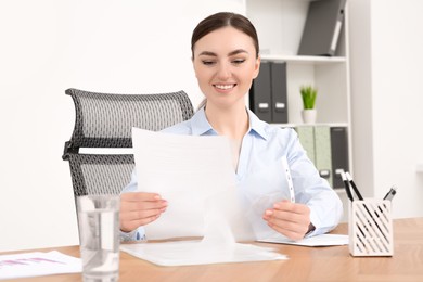 Photo of Businesswoman working with documents at wooden table in office