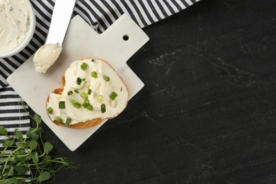 Delicious sandwich with cream cheese and chives on black table, flat lay. Space for text